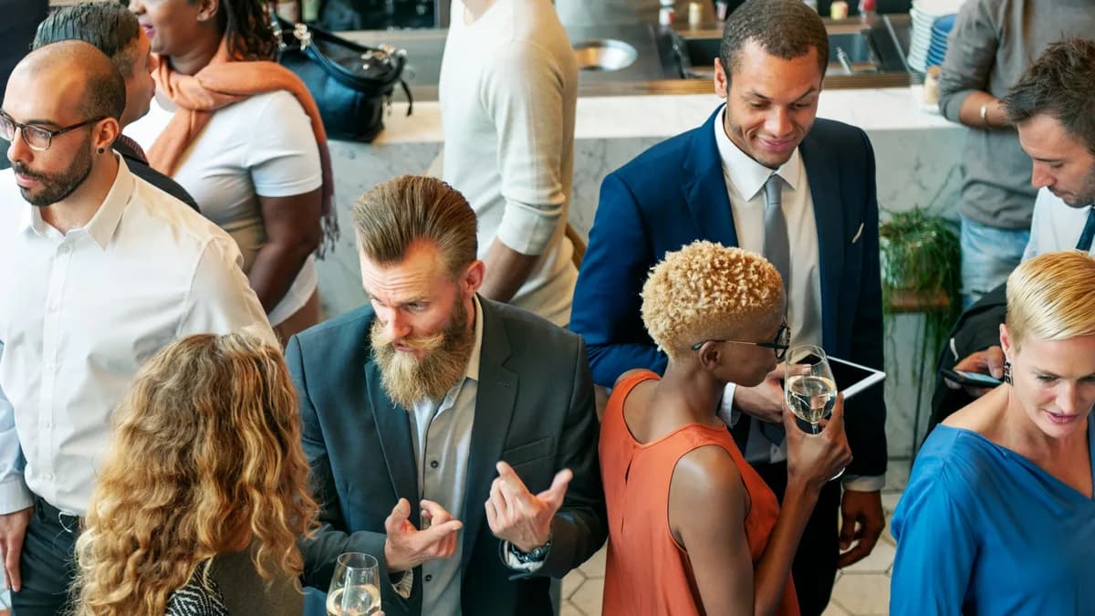 Collaborateurs échangeant debout lors d'un cocktail d'entreprise