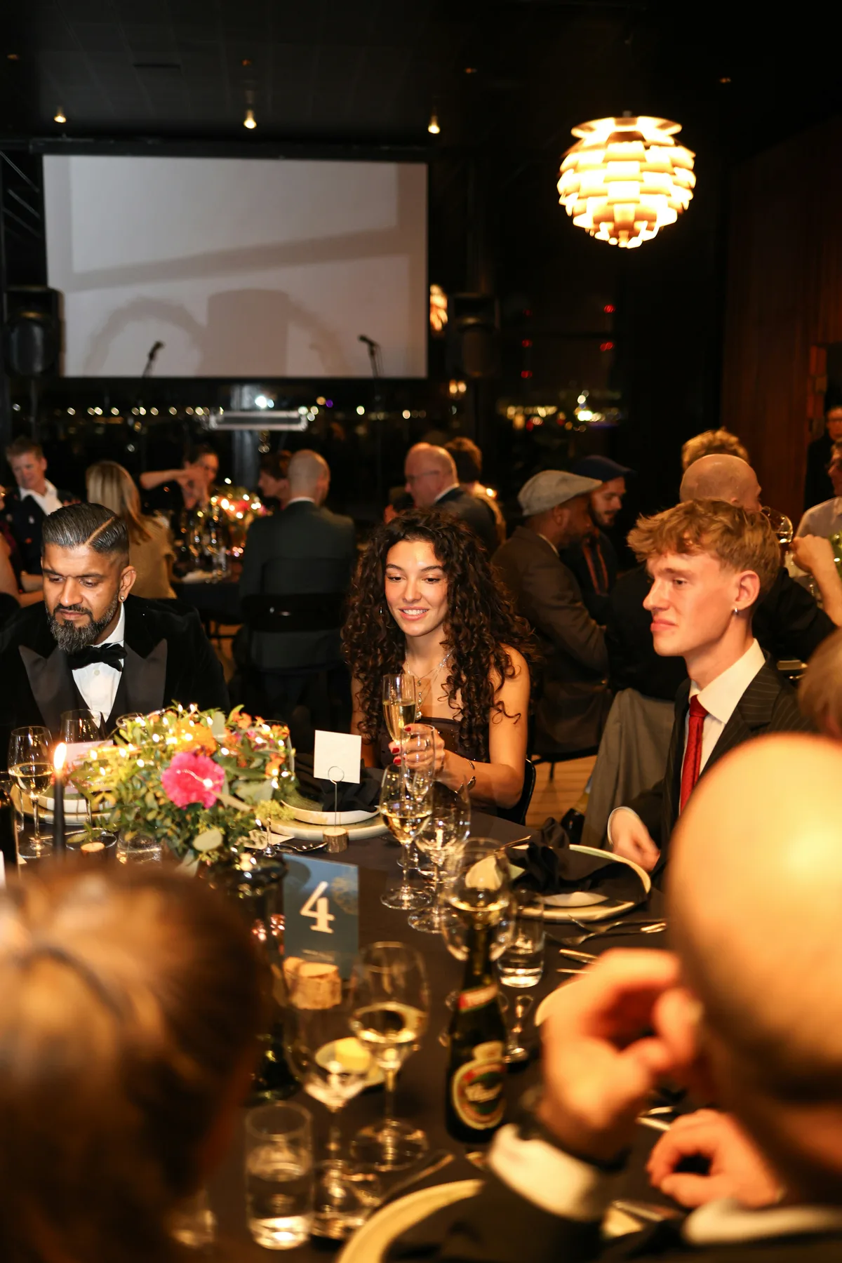 Convives en tenue de soirée attablés lors d'un dîner d'entreprise