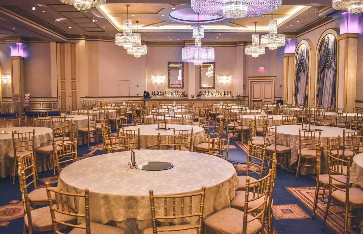 Salle de banquet dressée avec des tables rondes et leurs chaises